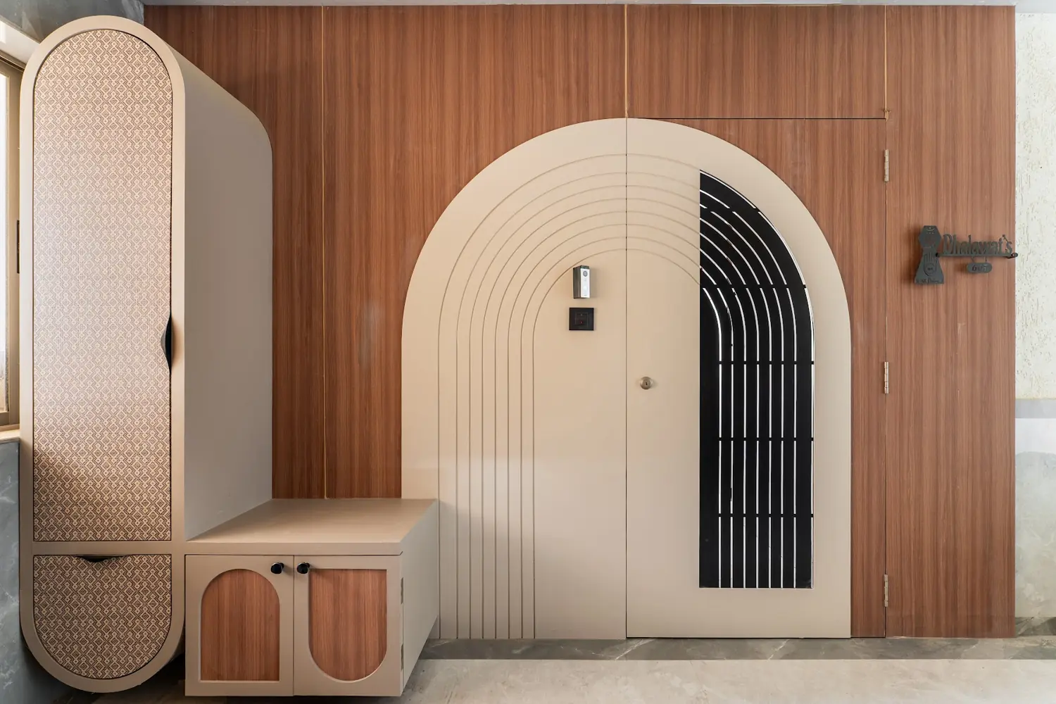 Arched entrance door with a fluted frame and iron grille