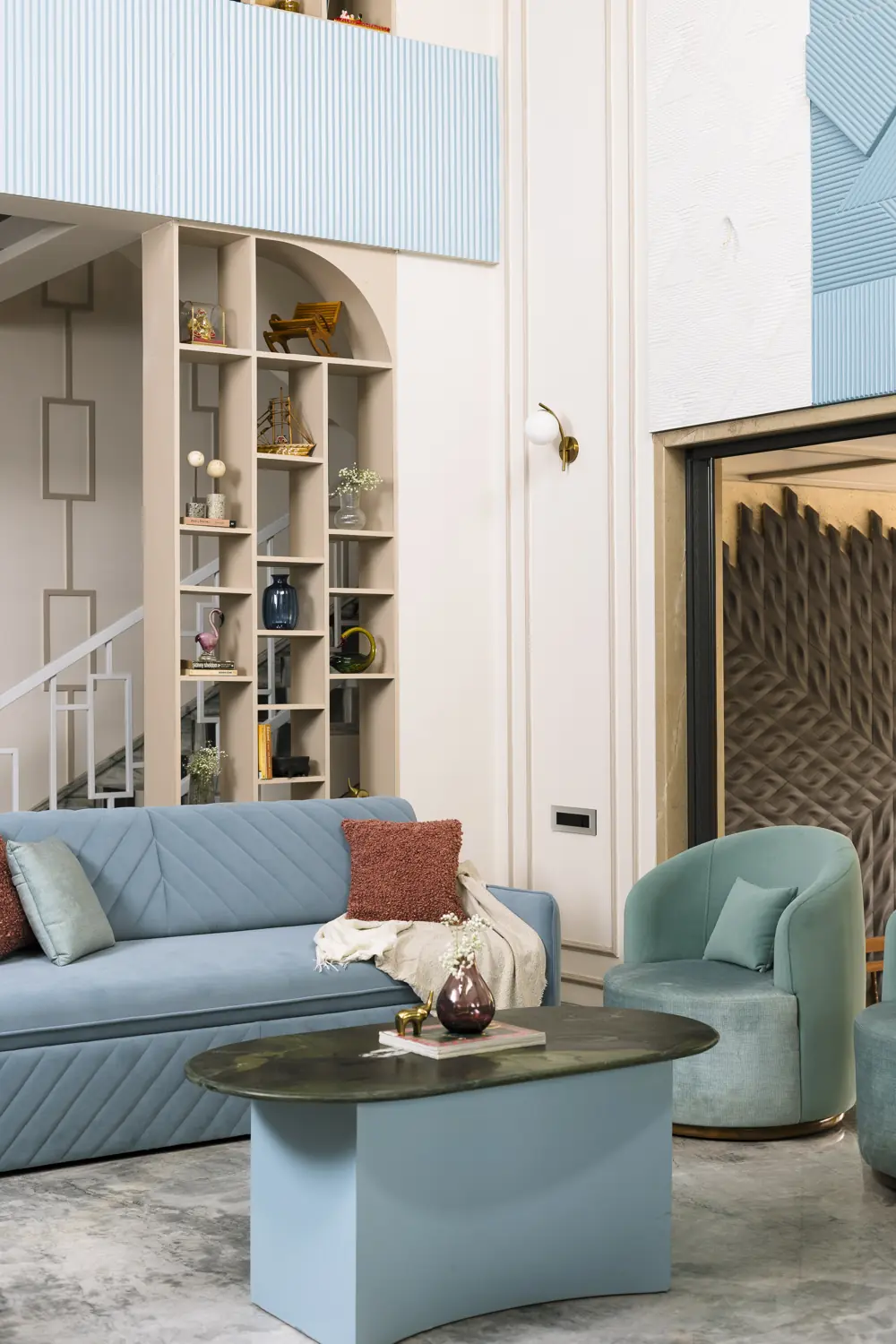 Sofa corner beside tall shelves under the double-height ceiling