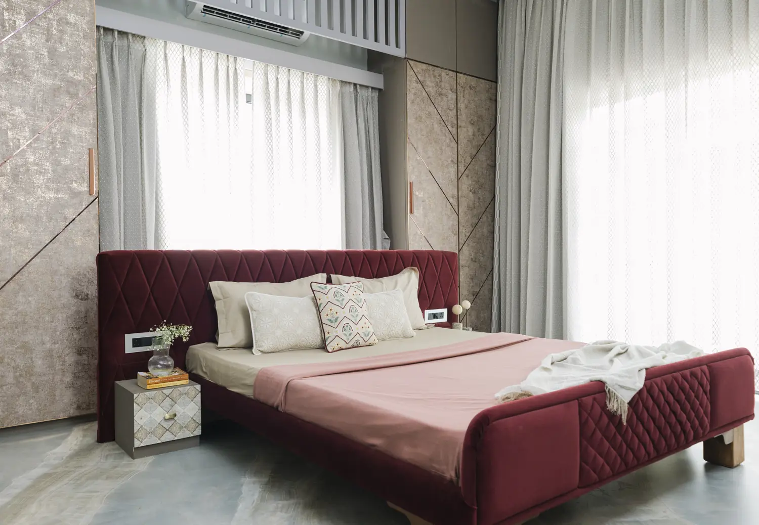 Bedroom with a plum quilted bed and grey diagonal panelling