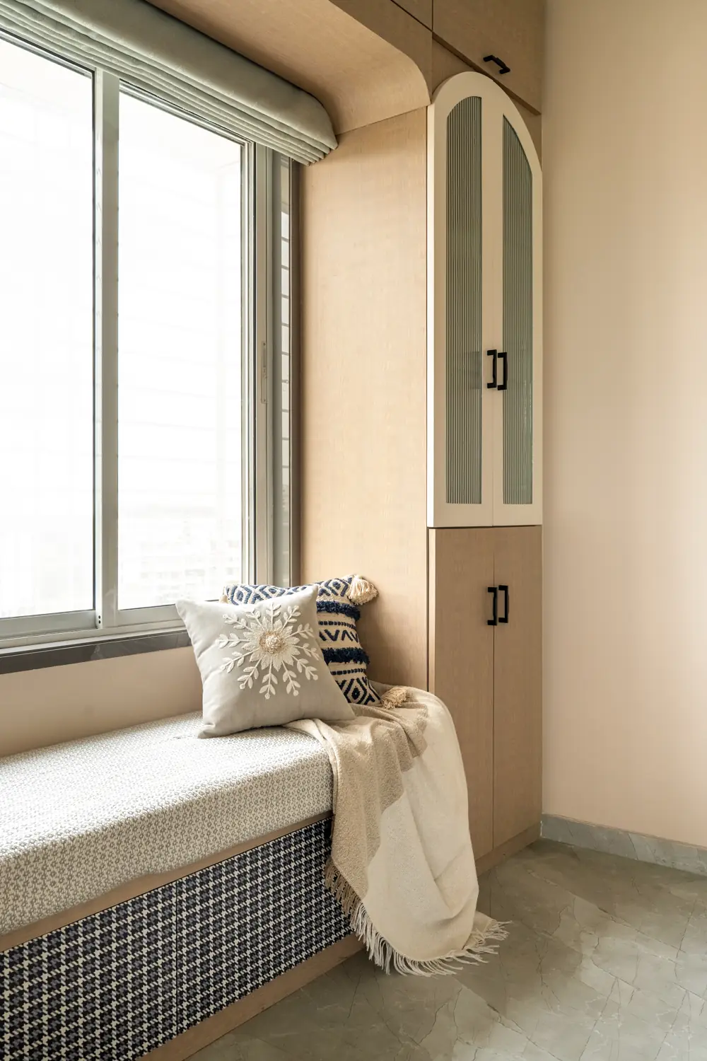 Window seat with a woven cushion and an arched cabinet